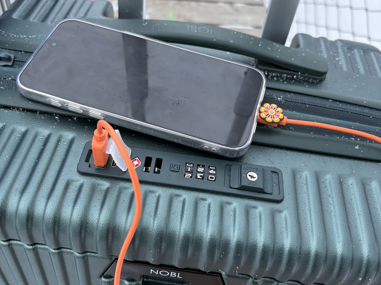 Cup and phone mounted on the NOBL Carry-On handle