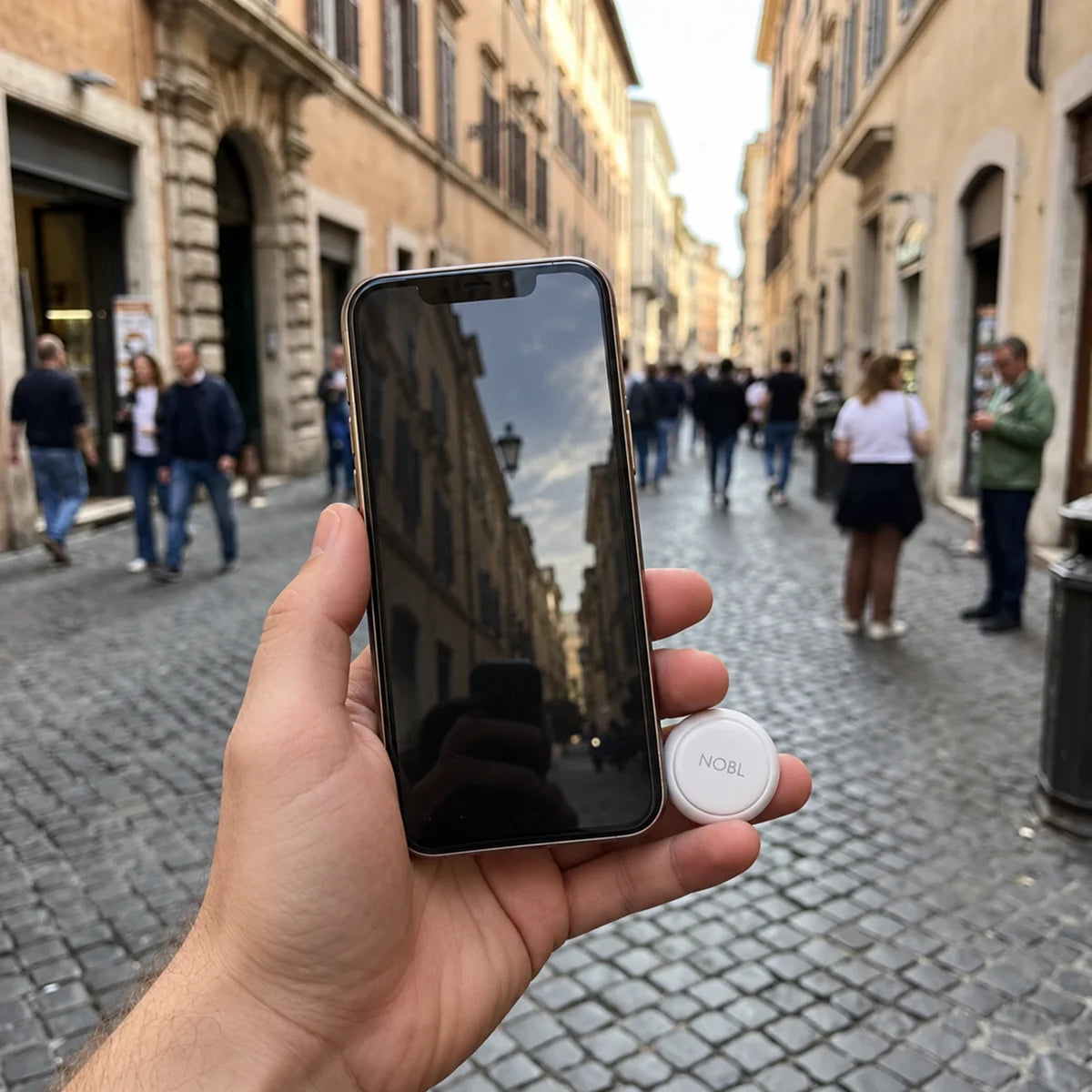 A traveller holding a phone and NOBL Air™ on a city street