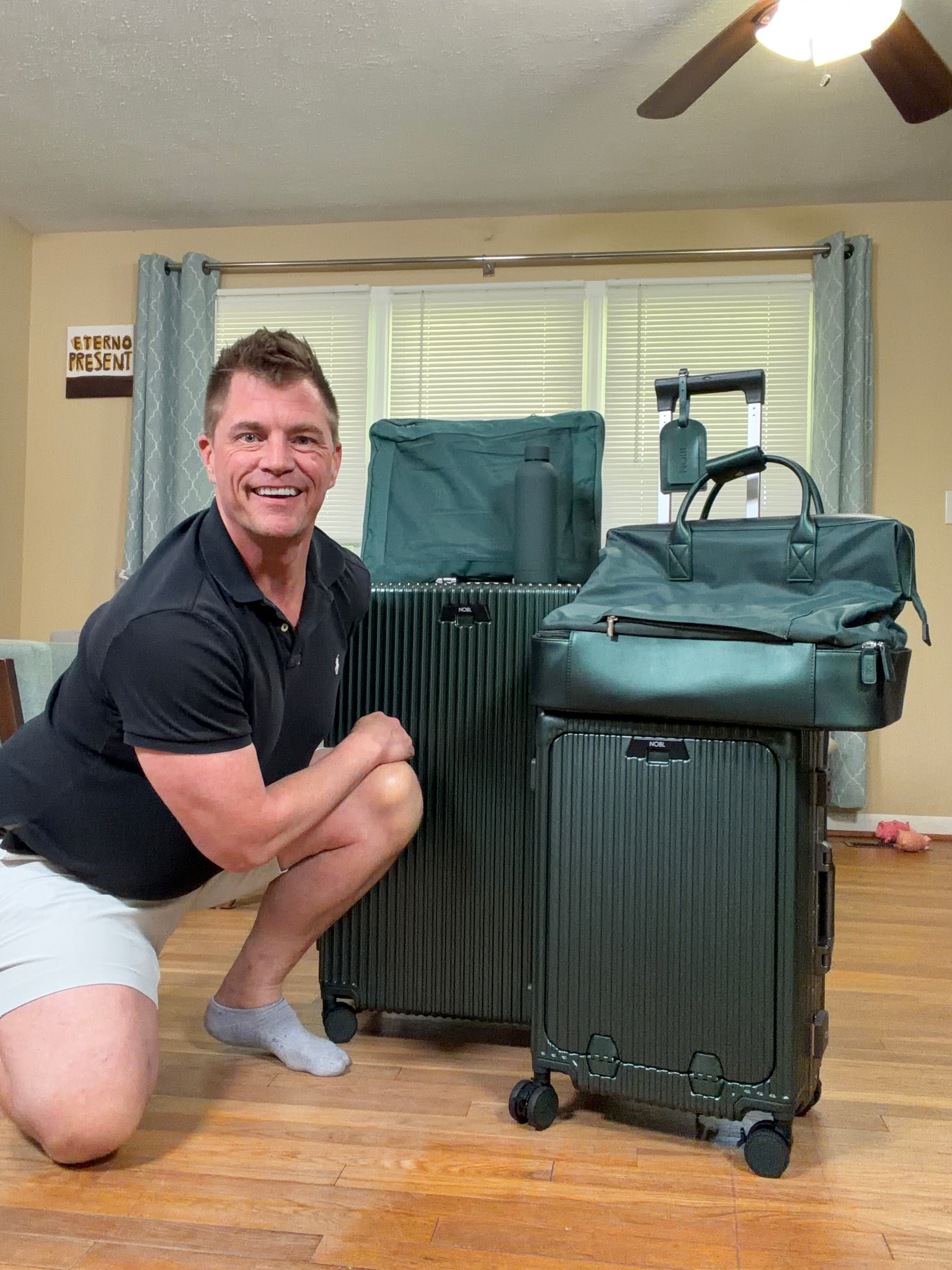 Smiling traveler with green luggage