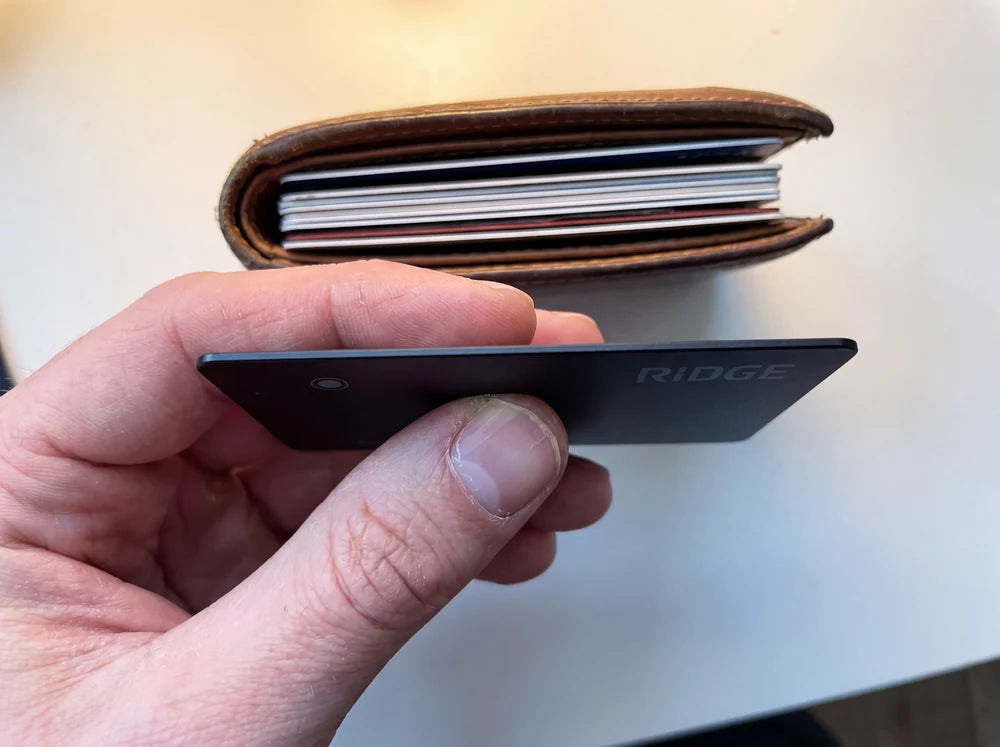 Ridge tracker card held edge on beside a wallet full of cards