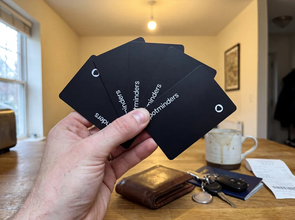 Five Spotminders tracking cards fanned out in one hand