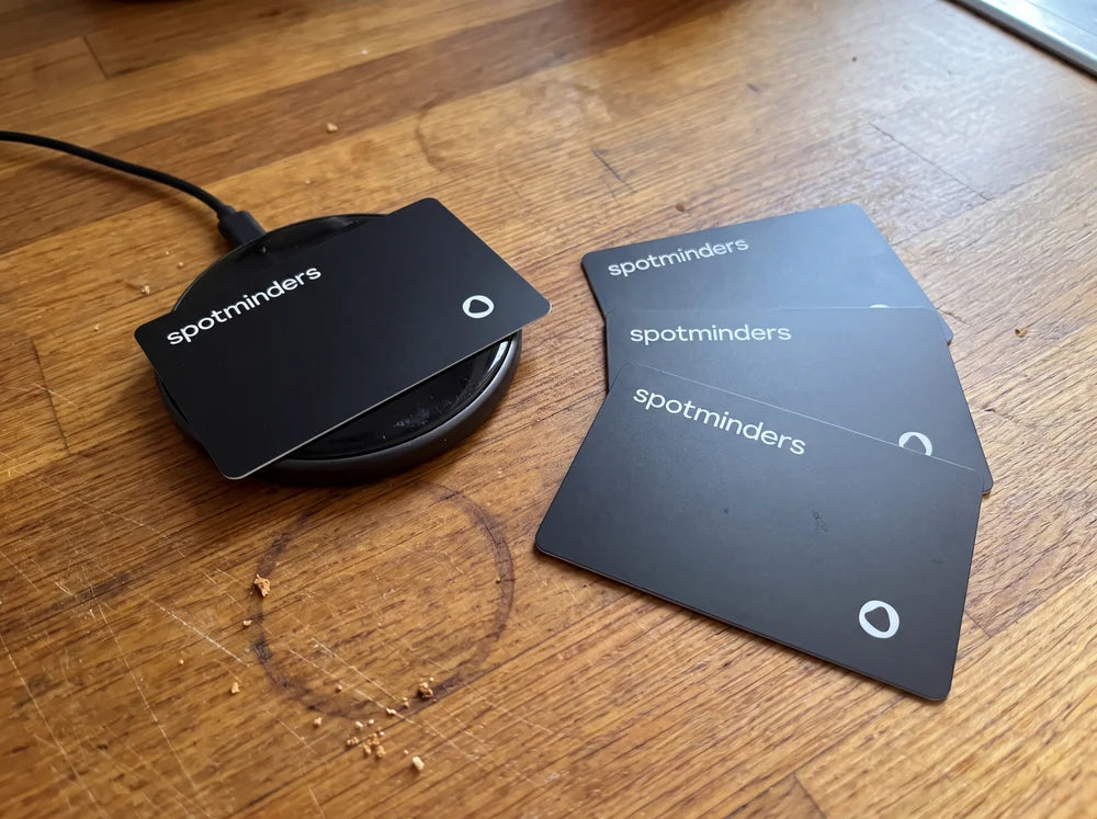 Spotminders wireless charger beside a stack of tracking cards